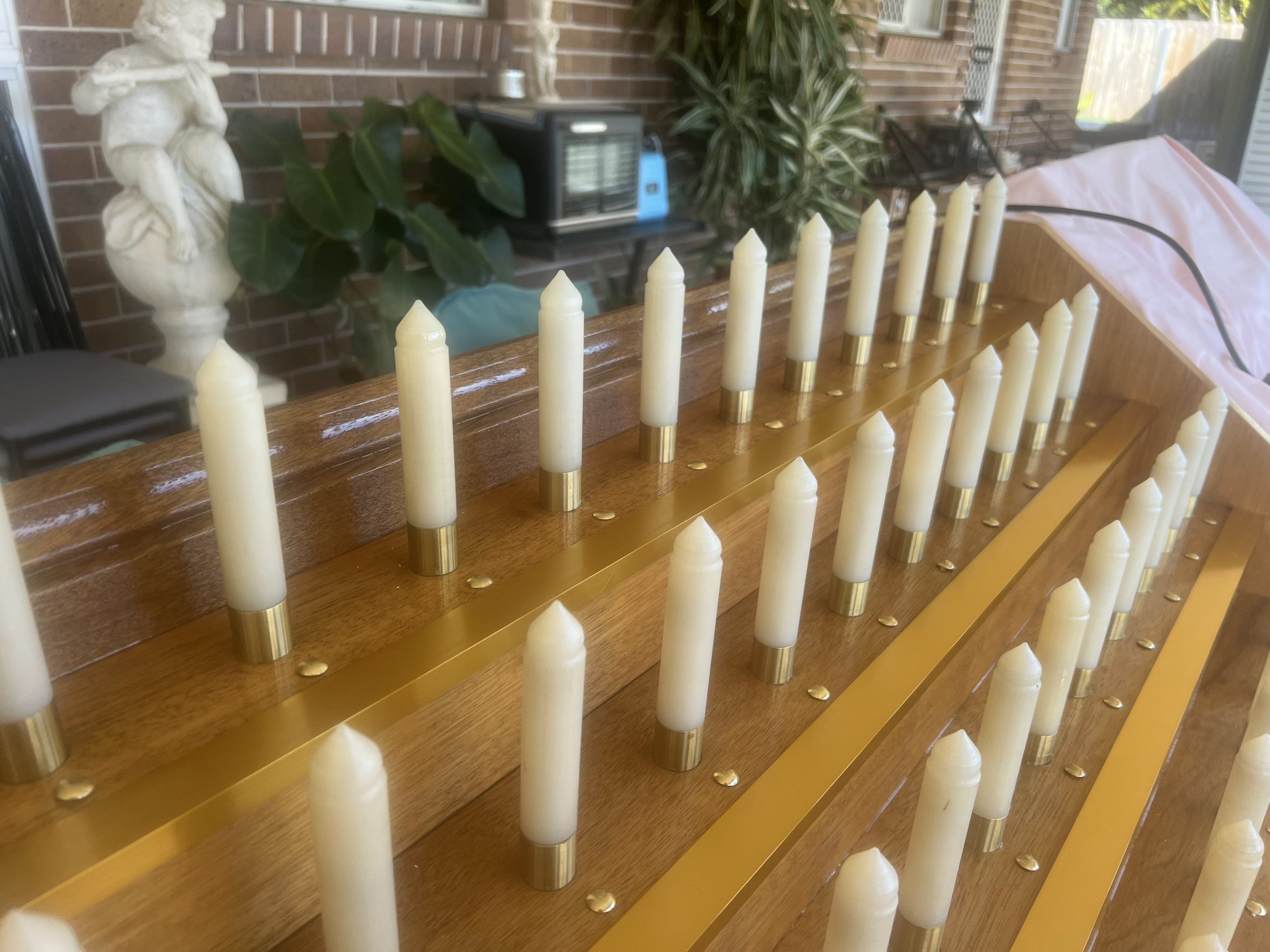 Gold anodised trim on the shelf edge of a reconditioned candle stand